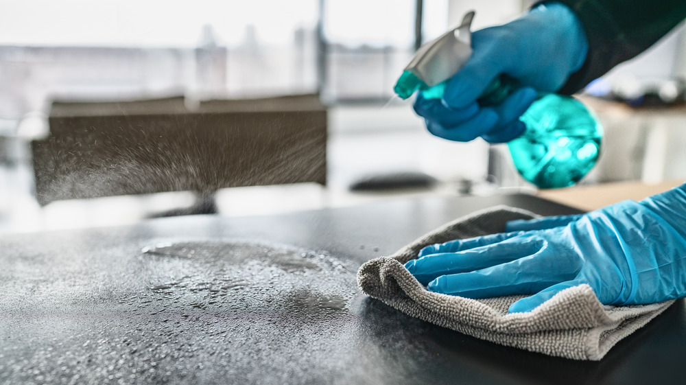 Sanitizer spray on table with gloves on