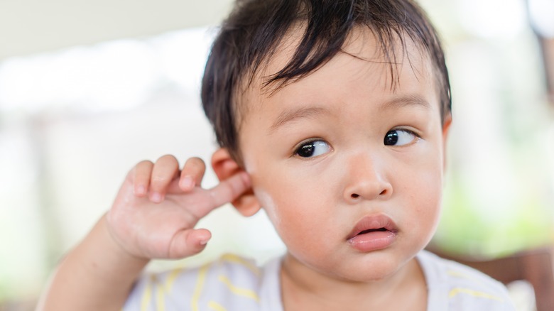 man holding ears