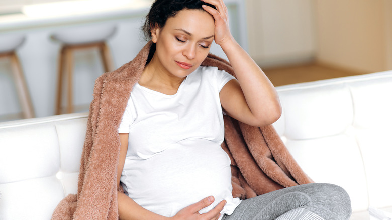 Sick pregnant woman on couch