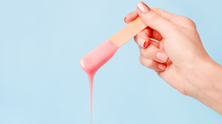 Close up of pink wax dripping from an applicator