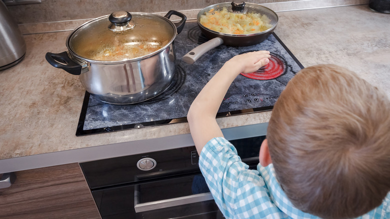 Child touching a hot stove