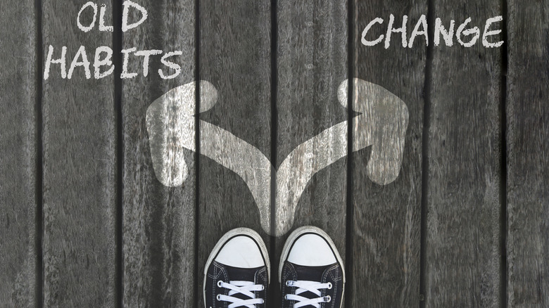 feet standing before arrows pointing to the words "old habits" and "change"