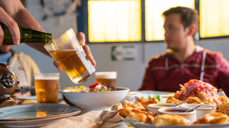 person pouring a drink for someone