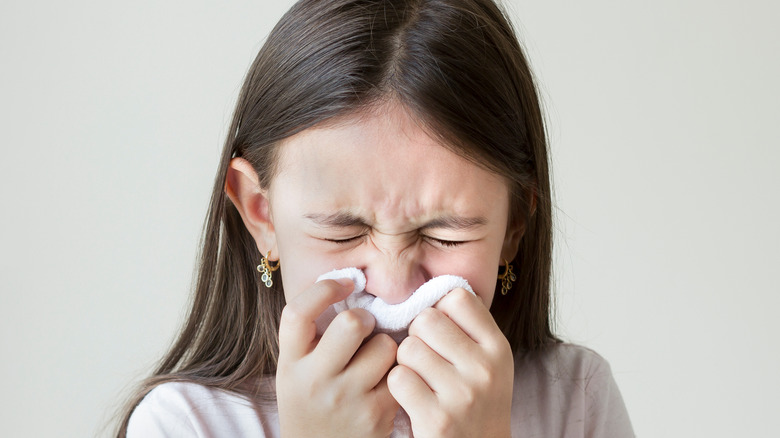 child blowing her nose