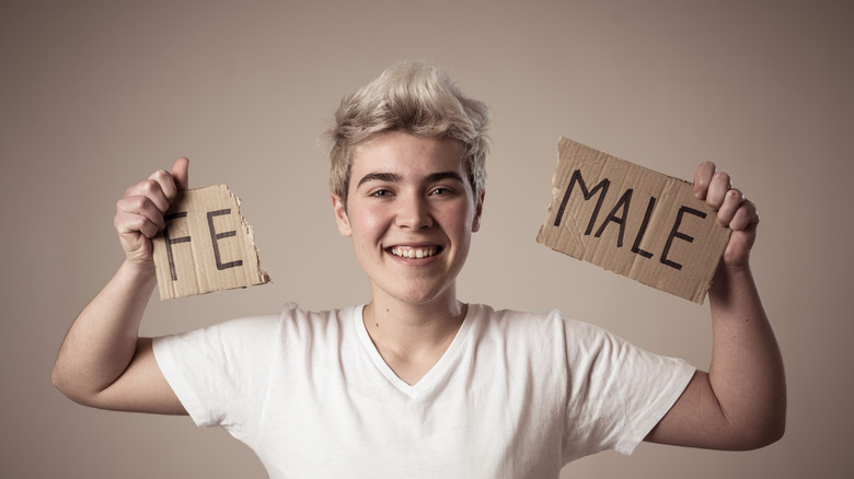 young transgender person holding up sign