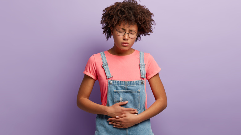 person holding bloated stomach