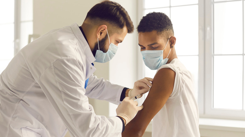 doctor vaccinating young man
