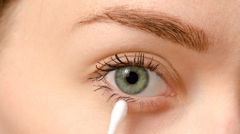 Woman with cotton swab near eye