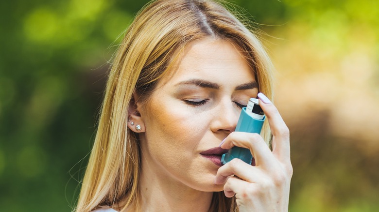 woman using asthma inhaler