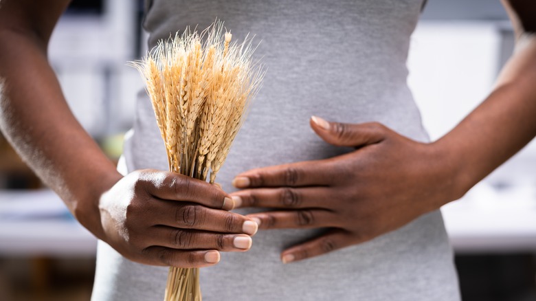Woman with celiac disease holding a wheat plant in her hands