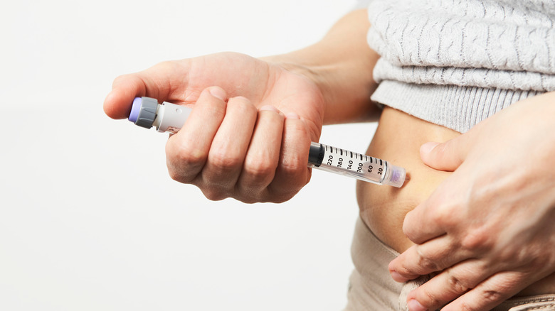 woman injecting insulin into herself