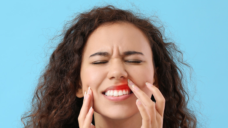 woman with gum inflammation on color background
