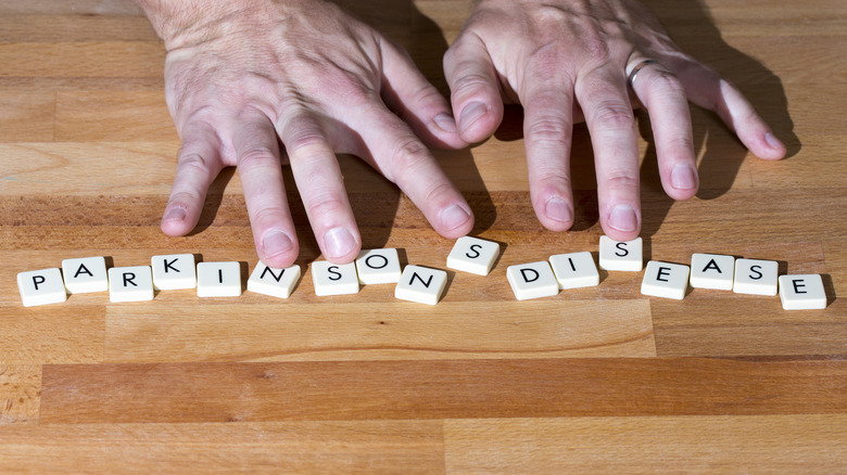 Close-up of hands above Parkinson's disease spelled out in Scrabble letters
