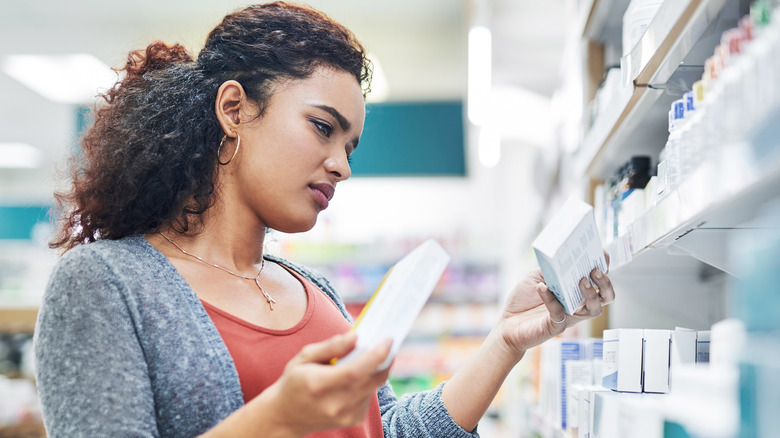 woman looking at different medications