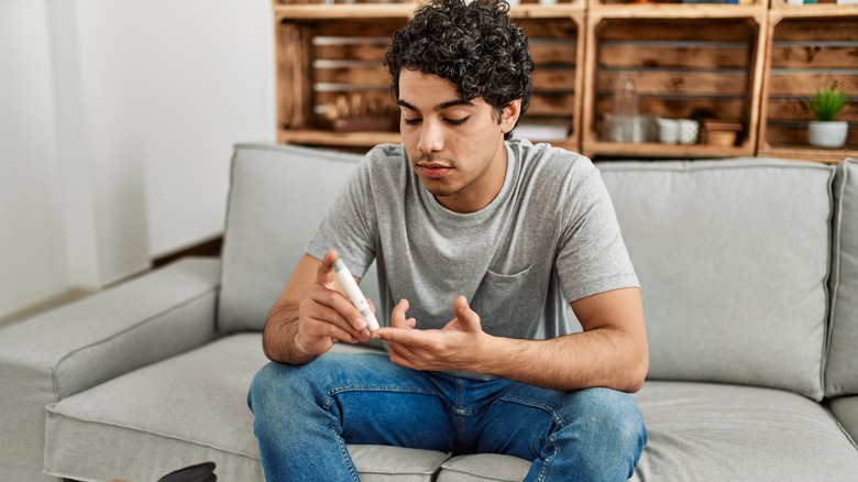 man with diabetes measuring glucose