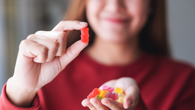 Woman holding red gummy bear
