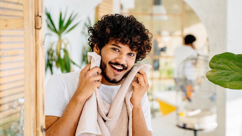 man holding towel to face