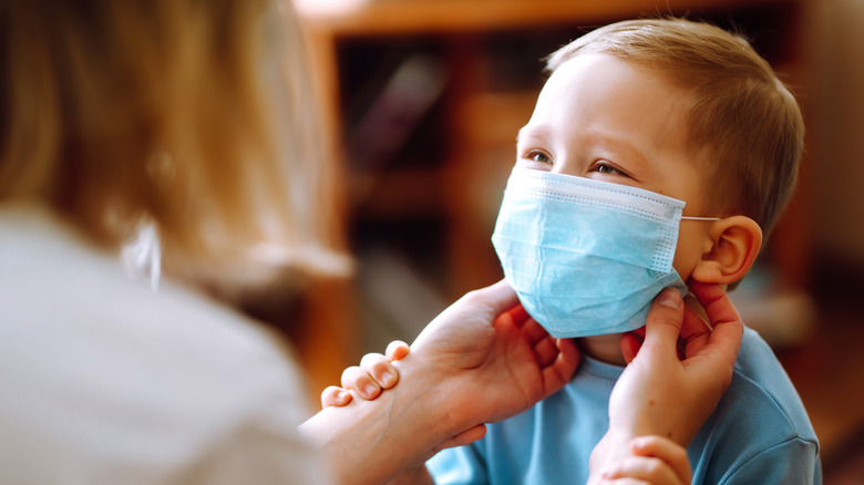 Parent adjusting mask on young child's face