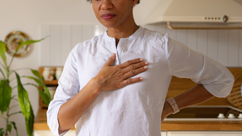 Woman with heartburn holding chest