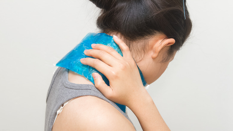 woman holding ice pack to neck