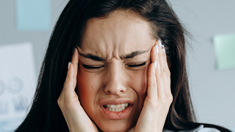 stressed out woman holding her temples