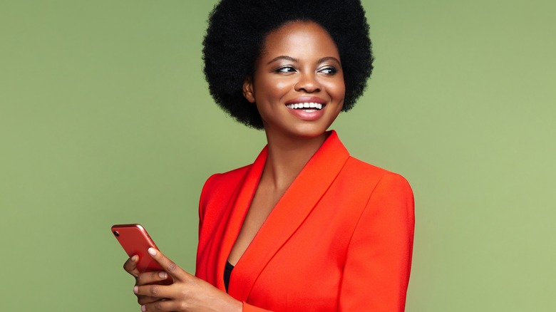 Black woman smiling with her cellphone