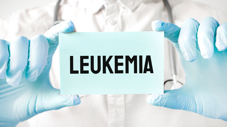 Doctor holding card in hands with the word LEUKEMIA