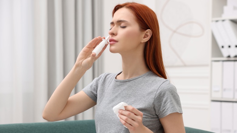 A woman using a nasal sinus spray