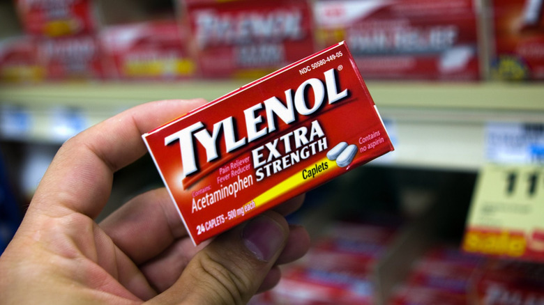 woman taking Tylenol off shelf