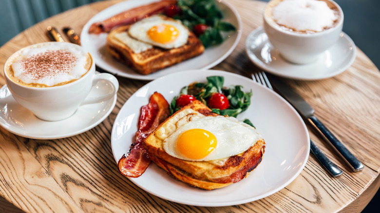 A hearty breakfast with eggs, toast, bacon, and a latte