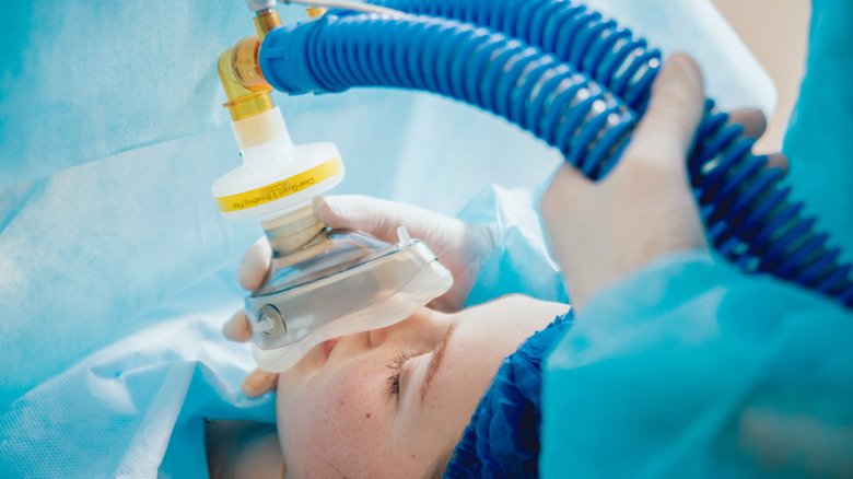 Medical professional applying an oxygen mask to a patient