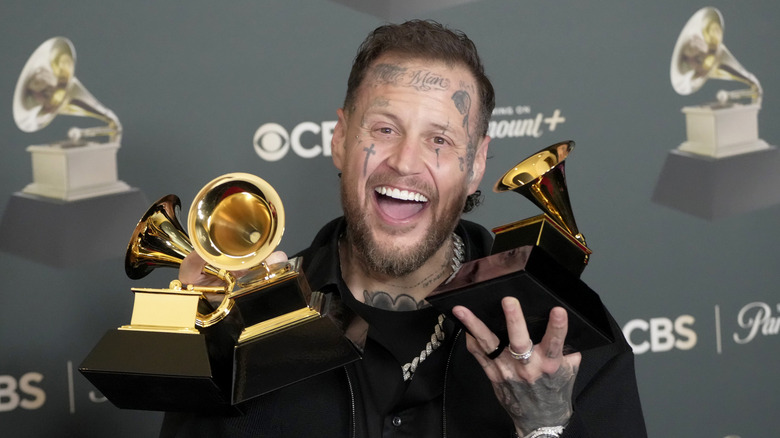 Rapper Jelly Roll holding Grammy awards