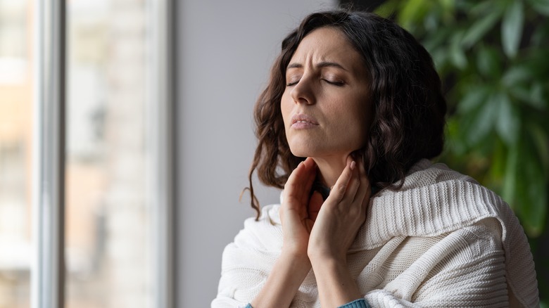 woman feeling touching neck glands
