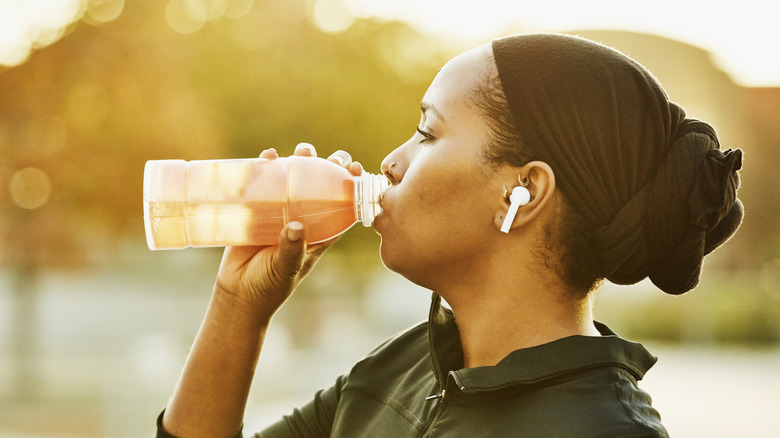 A woman drinking sports drink during her workout