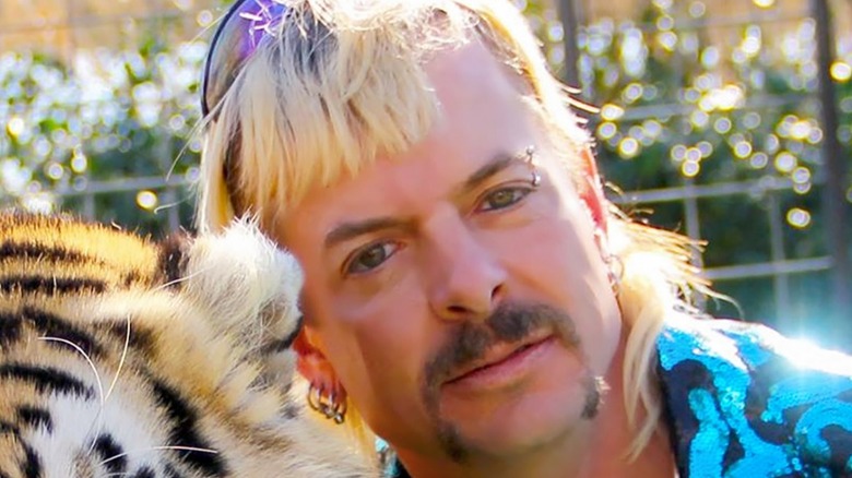 Close up of Joe Exotic's face next to tiger