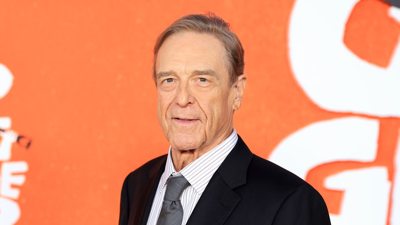 John Goodman posing in a suit