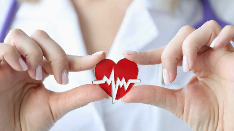 Doctor hands holding heart pin