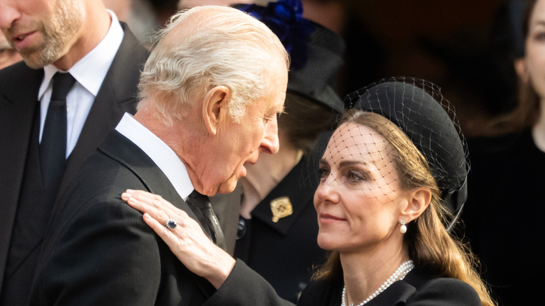 Kate Middleton touching King Charles III's shoulder