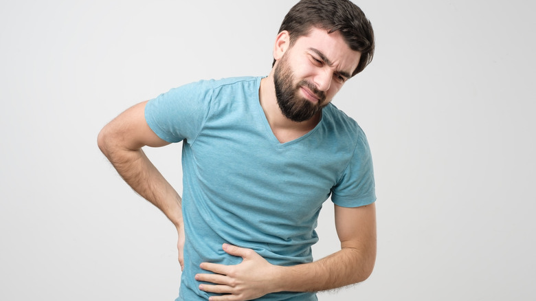 man with kidney stones holding his side in pain