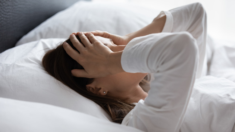 Woman in bed with migraine