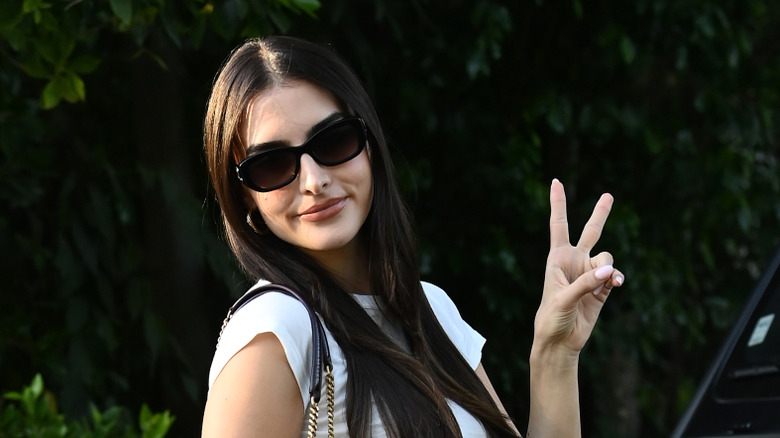 Sophia Umansky wearing shades and doing a peace sign in 2025