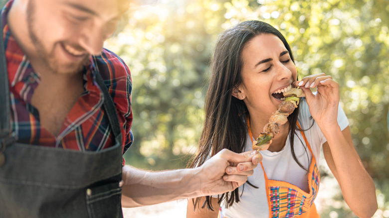 Woman eating grilled kabob