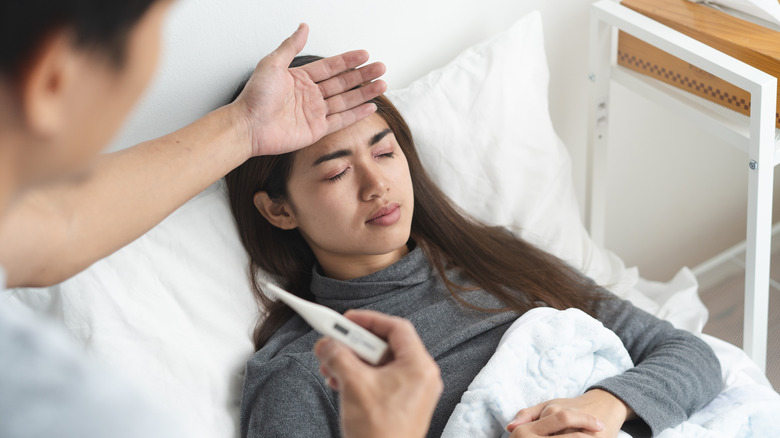 sick woman laying in bed