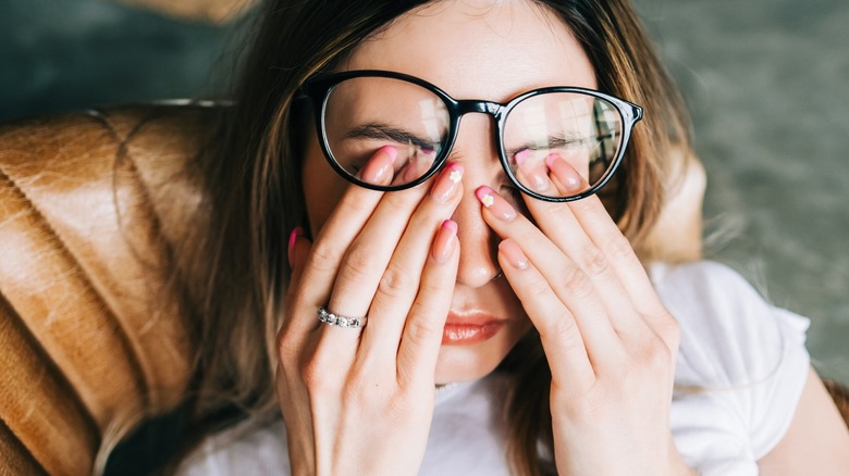 woman rubs tired eyes 