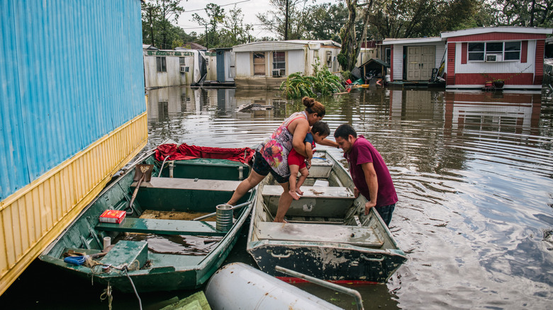 Family affected by flooding getting into rescue boat