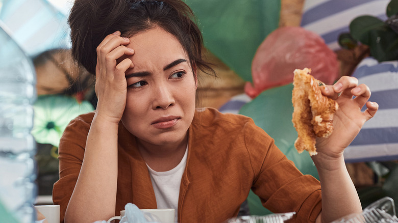 woman showing disgust over leftovers