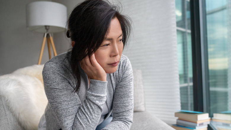 Distressed woman sitting on armchair