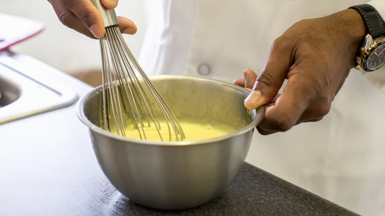 man mixing together egg product