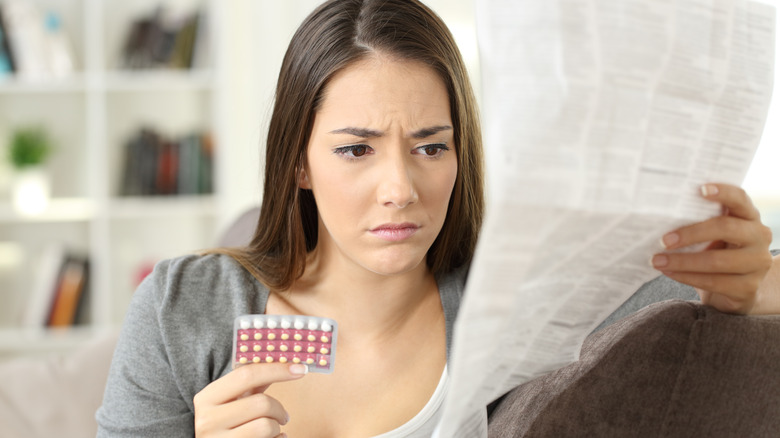 woman holds a pack of birth control pills 