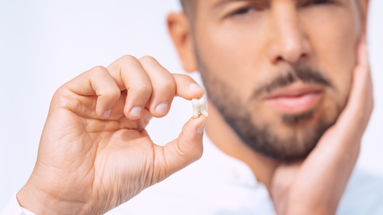 Man holds tooth
